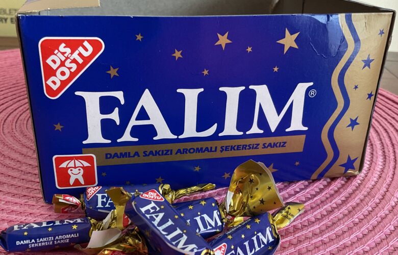 Box of chewing gum with pieces on table in front. Box says "Falim."